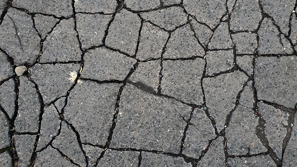 Interlocking alligator cracking across an asphalt surface where the base beneath has failed